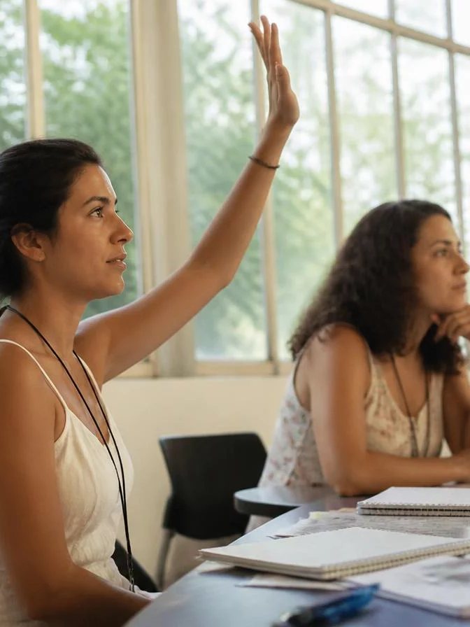 Dupla preparando uma rodada com cadernos abertos e canetas marcadoras sobre a mesa